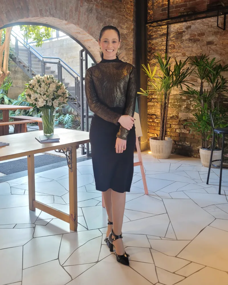 Andreia Lourenço em pé no salão de um evento que produziu