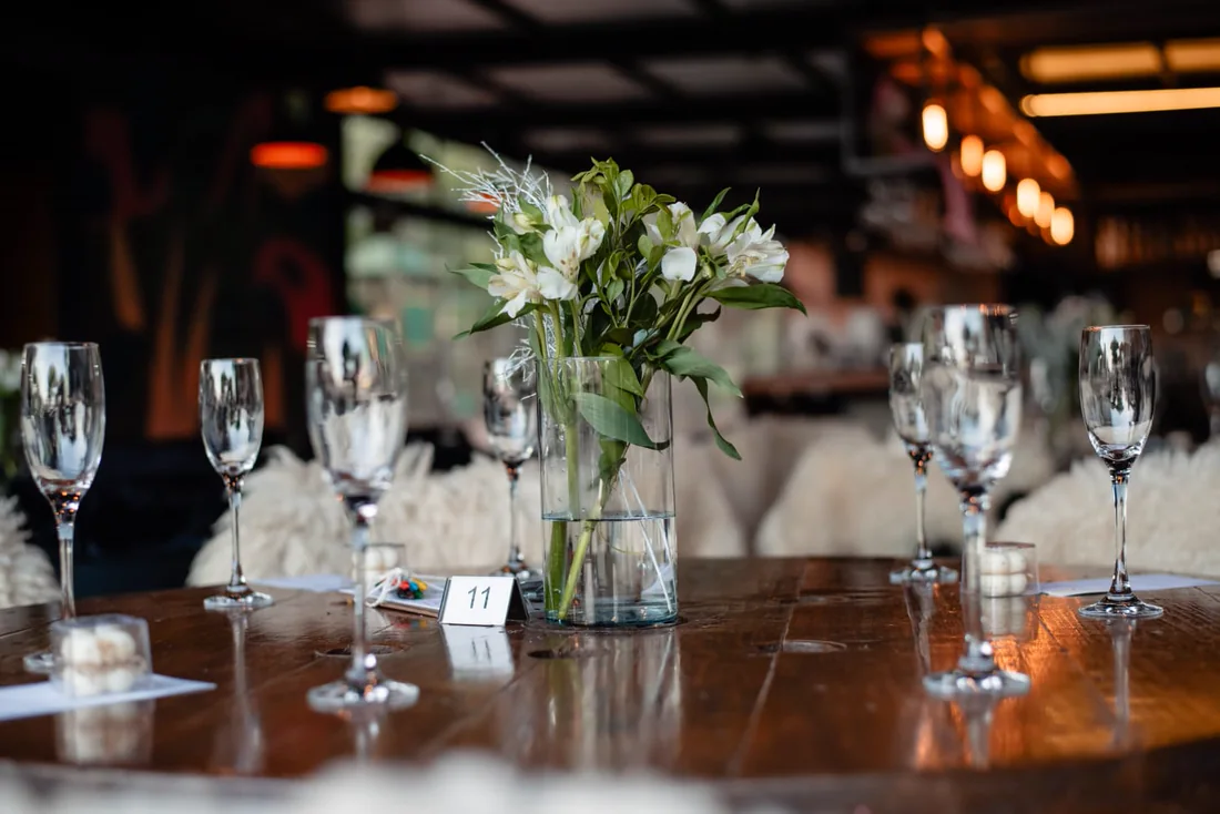 Mesa posta com taças e arranjo de flores brancas ao centro